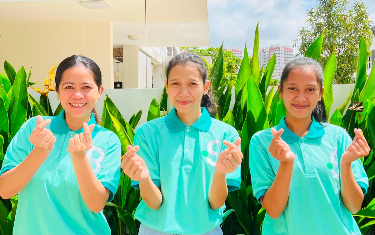 Smiling domestic helpers placed through Green Employment sharing a warm moment