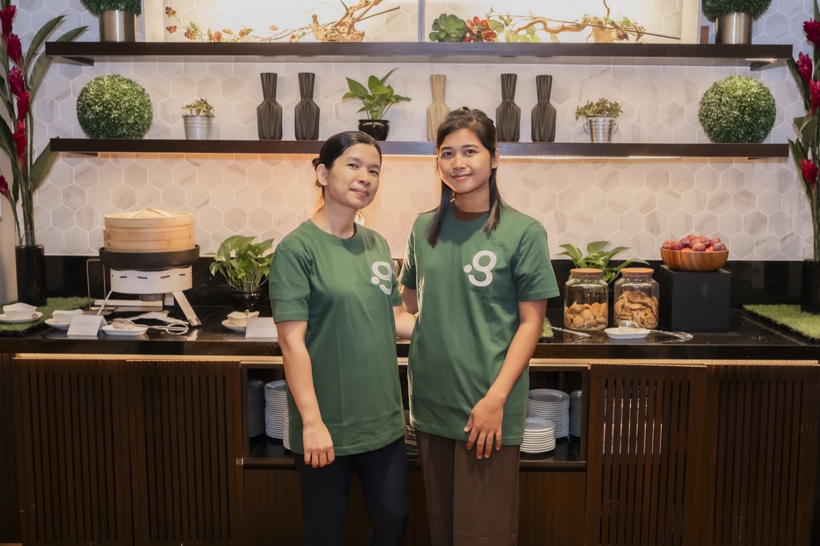 Domestic helpers placed through Green Employment, smiling in the green uniform